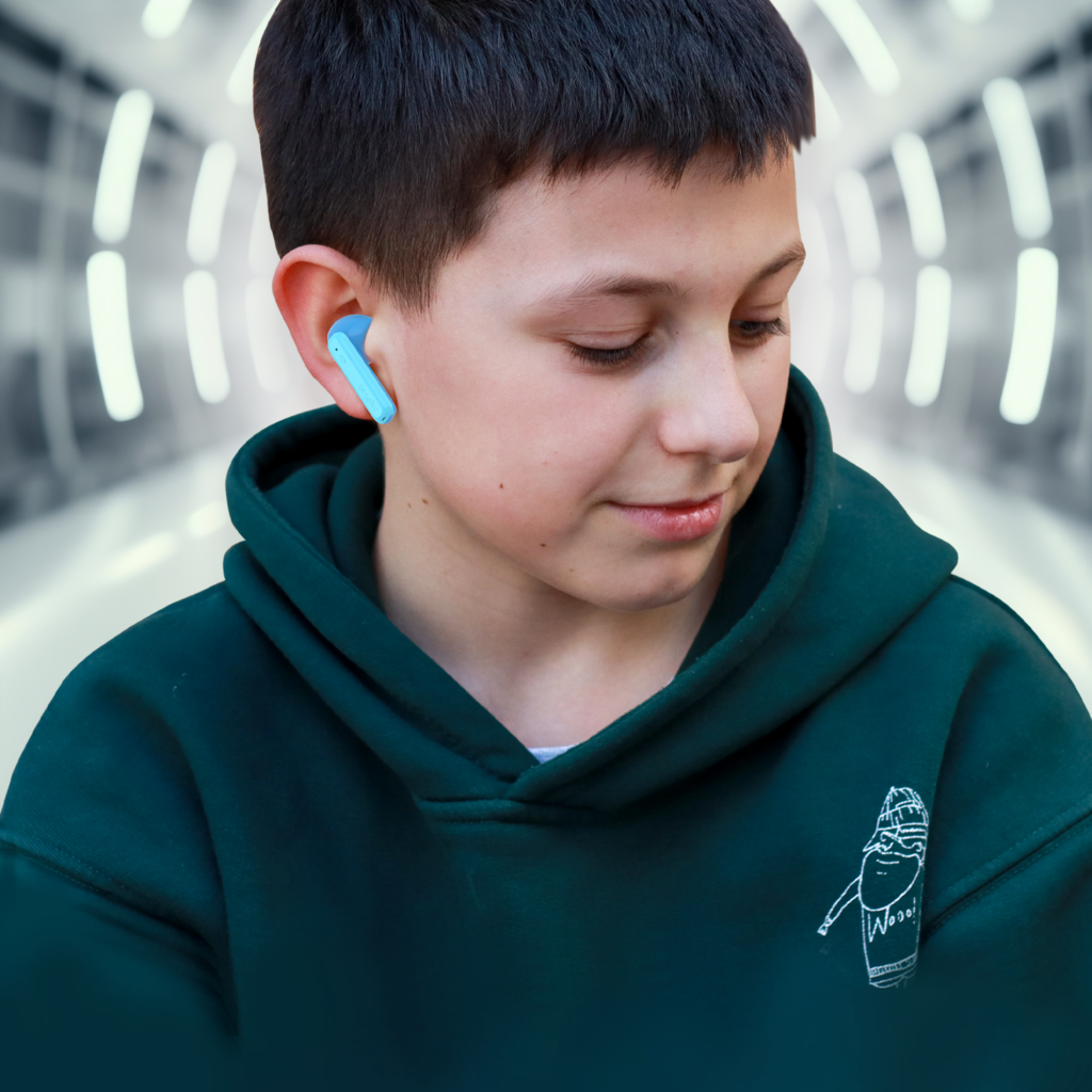 A young boy wearing safe headphones for kids in his ears