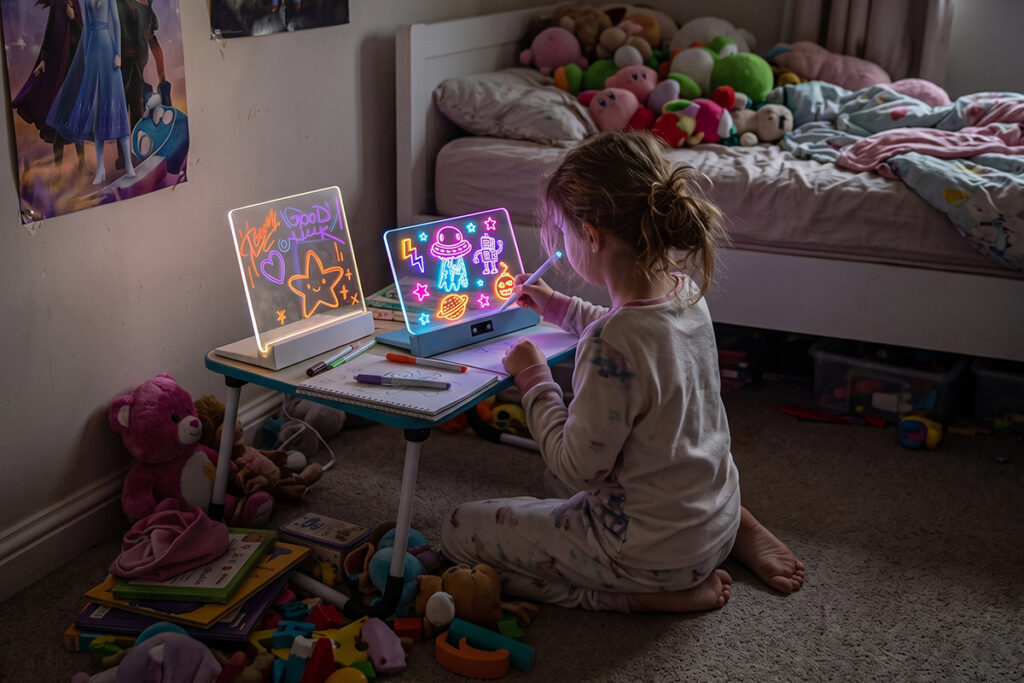 A girl using two Sketch Board Clears in her messy bedroom